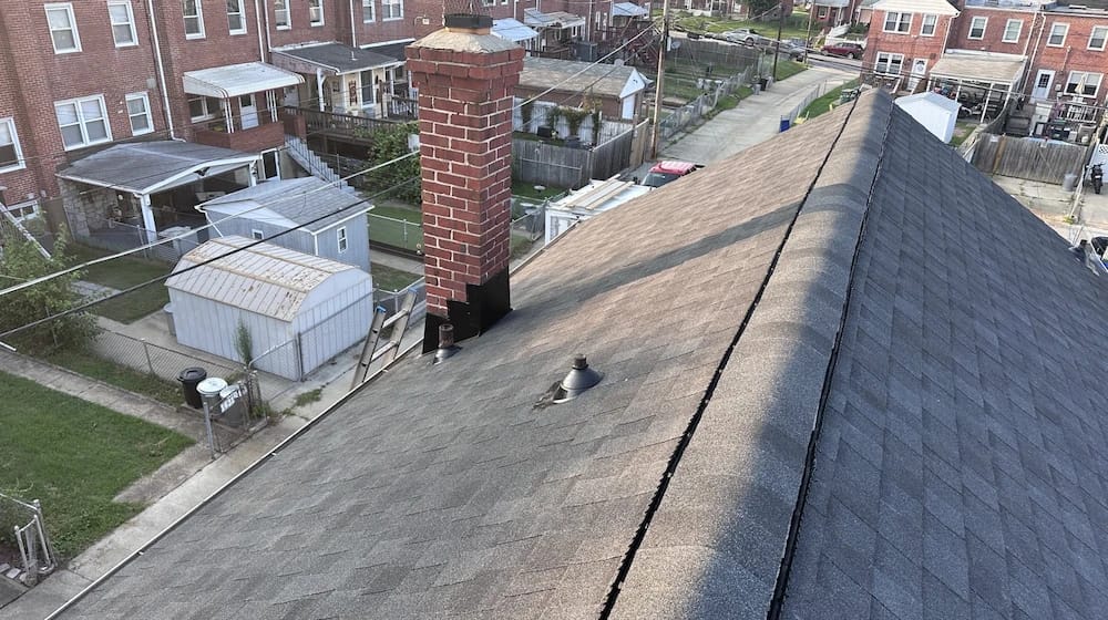 Finished asphalt shingled roof with new chimney flashing. 
