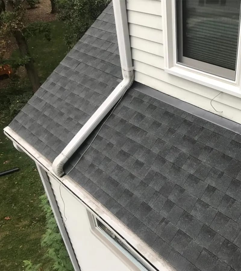 A detached shed with a green standing seam metal roof. 