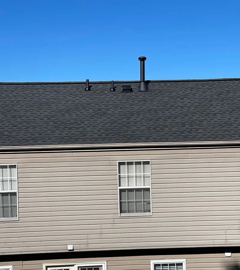 A detached shed with a green standing seam metal roof. 
